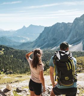 Two hikers are enjoying the view on the mountains in summer